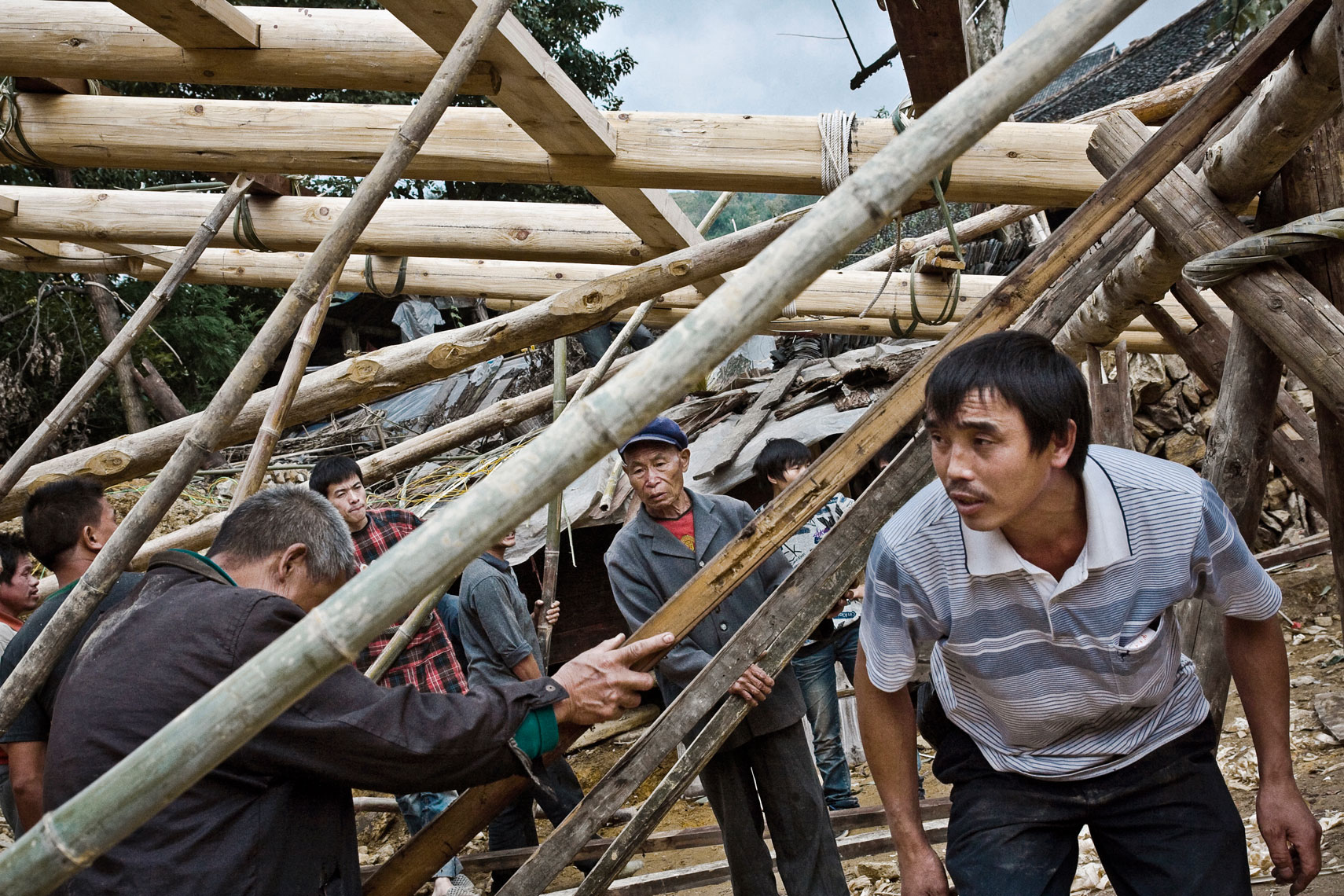 CHINA. Guangxi Province, September 2012. Zhongliu village. Men of the village during the construction of a traditional wood house.